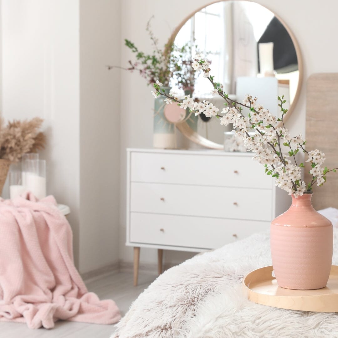 a bedroom with white and pink furniture and decor