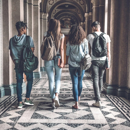 a photo of 4 students walking down the hall