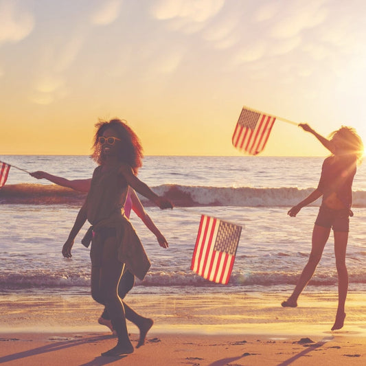 children running on the beach with american flags